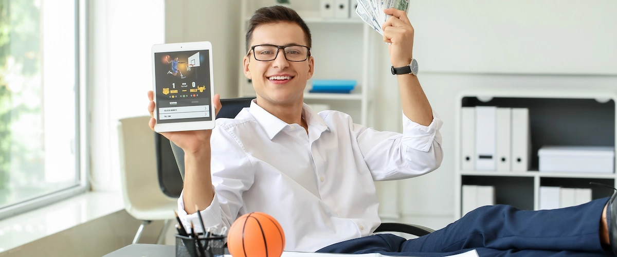 Young businessman placing sports bet in office. Concept of NBA betting